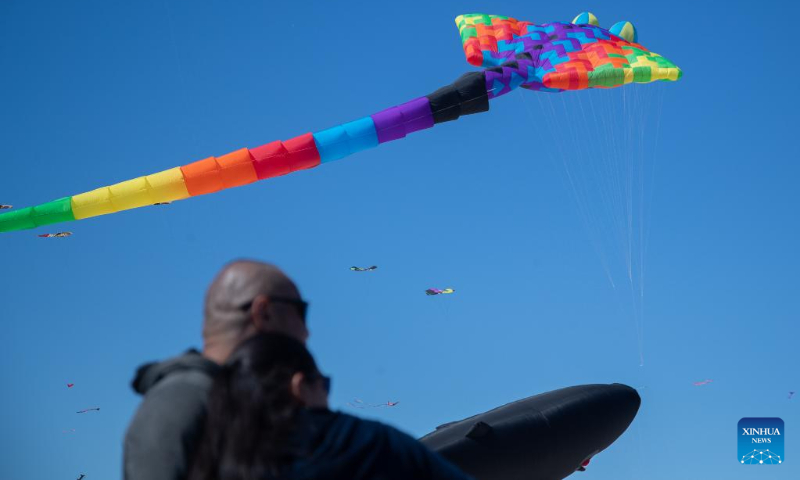 People watch kites flying above Bondi Beach in Sydney, Australia, Sept. 10, 2023. Kite lovers flocked to Sydney's famous Bondi Beach on Sunday for Australia's annual kite festival, the Festival of the Winds. (Photo by Hu Jingchen/Xinhua)