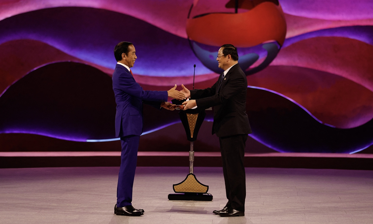 Presiden Indonesia Joko Widodo (kiri) menyerahkan palu ASEAN kepada Perdana Menteri Laos Soneksay Sifandon pada upacara penutupan KTT Perhimpunan Bangsa-Bangsa Asia Tenggara (ASEAN) ke-43 di Jakarta pada 7 September 2023. Foto: AFP