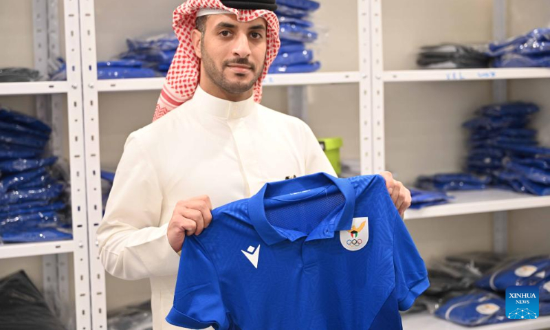 A man displays a uniform of the Kuwaiti national team for the upcoming Hangzhou Asian Games at the Kuwait Olympic Committee in Jahra Governorate, Kuwait, Sept. 10, 2023. (Photo by Asad/Xinhua)