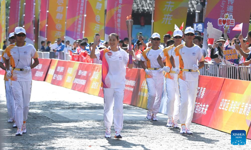 Torch bearer Lu Minjia runs with the torch during the torch relay of the 19th Asian Games in Shaoxing, east China's Zhejiang Province, Sept. 11, 2023. (Xinhua/Xu Yu)