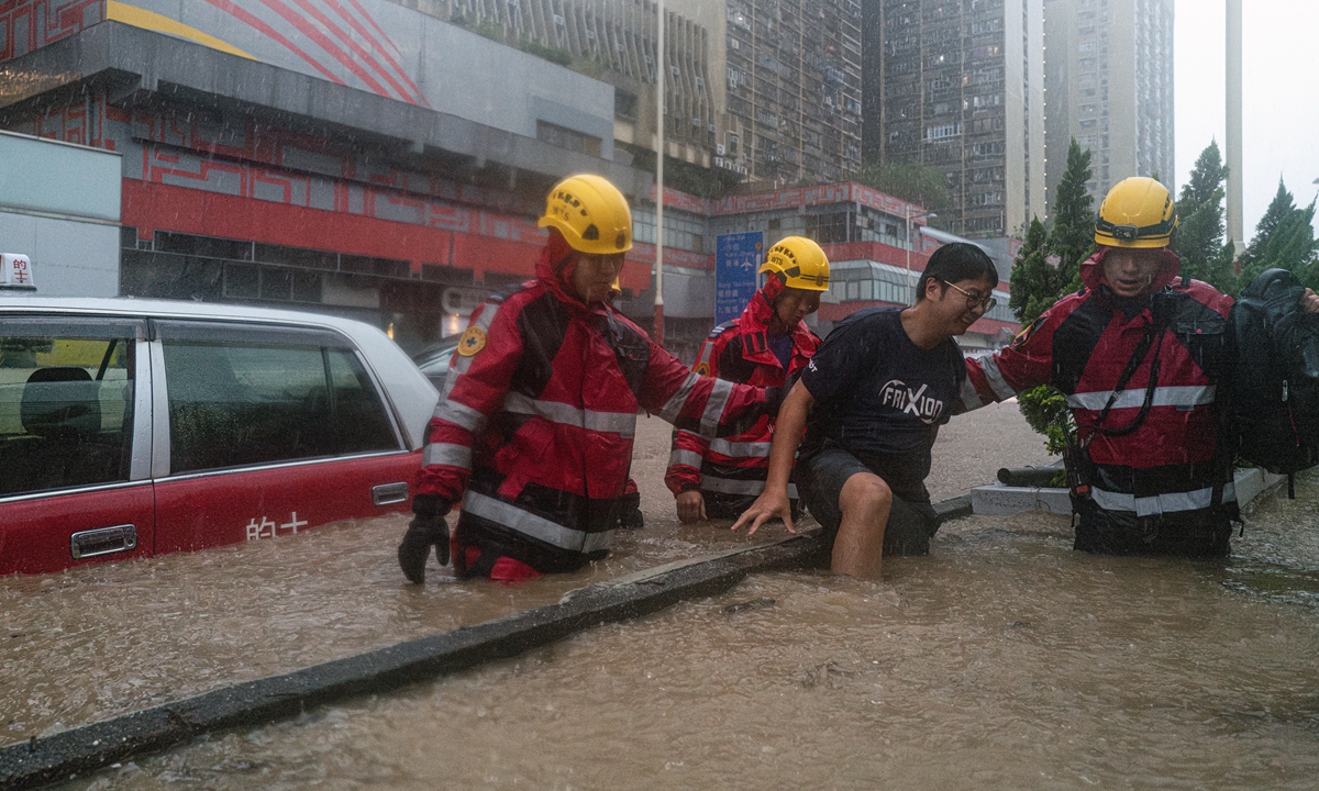 Rescue workers help a stranded resident in Hong Kong Special Administrative Region on September 8, 2023, as the city is inundated in the heaviest rainfall since records began in 1884. Photo: VCG 