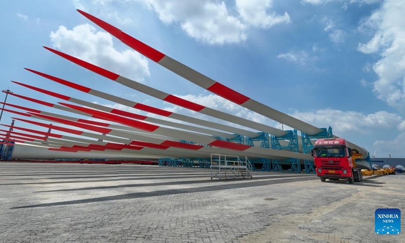 This aerial photo taken on Sept. 8, 2023 shows wind turbine blades ready for transportation at a port in Yancheng, east China's Jiangsu Province. Yancheng has boosted green and low-carbon development by advancing new energy industries such as wind and photovoltaic power in recent years. Photo: Xinhua