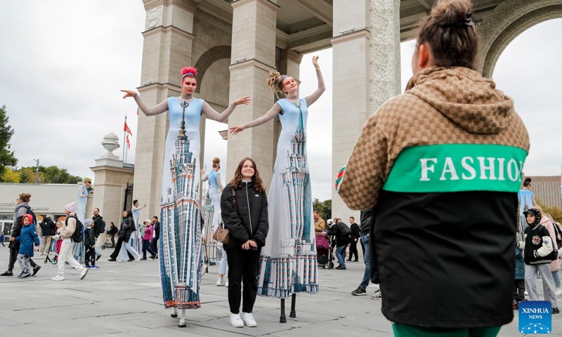 A girl poses for a photo with actresses dressed as Moscow's buildings during Moscow City Day celebrations in Moscow, Russia, Sept. 9, 2023. A series of events are held on this weekend to celebrate Moscow City Day and to mark the city's 876th founding anniversary. Photo: Xinhua