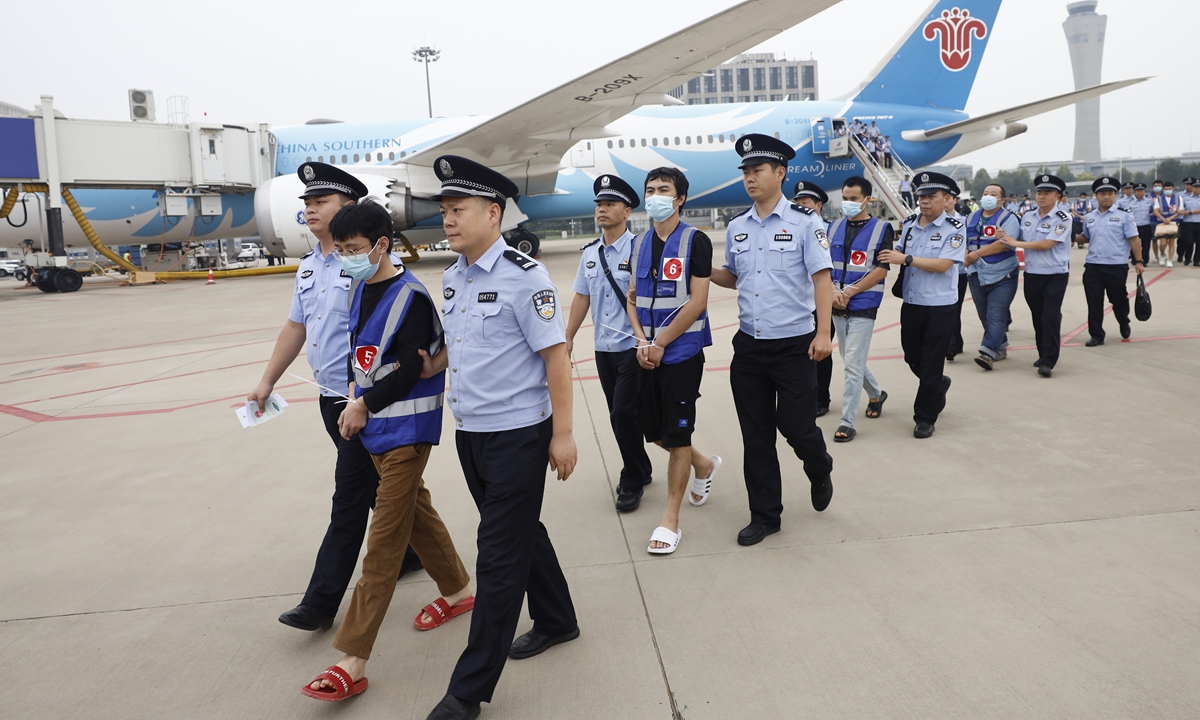 Police officers escort telecommunications fraud suspects from a charted plane arriving from Laos at the Zhengzhou Xinzheng International Airport in Henan Province on September 11, 2023. Photo: Li Hao/GT