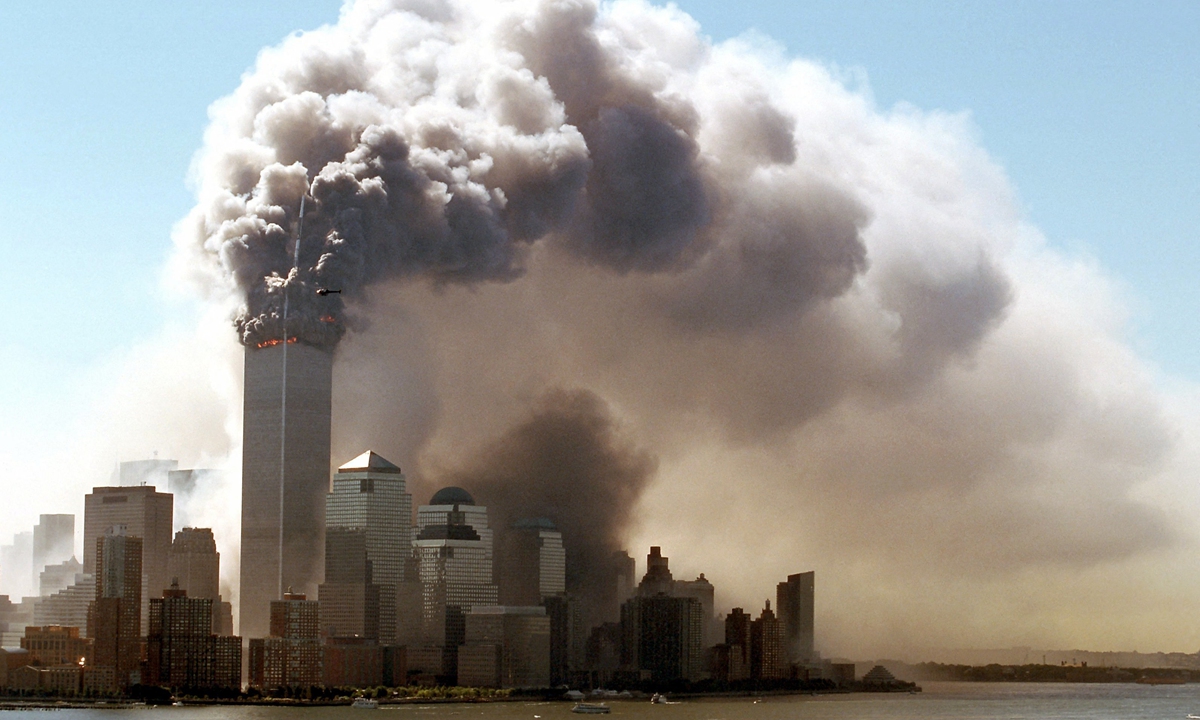 Clouds of smoke rise from the burning upper floors just before the twin towers of the World Trade Center in New York collapse, 11 September 2001.Photo: AFP