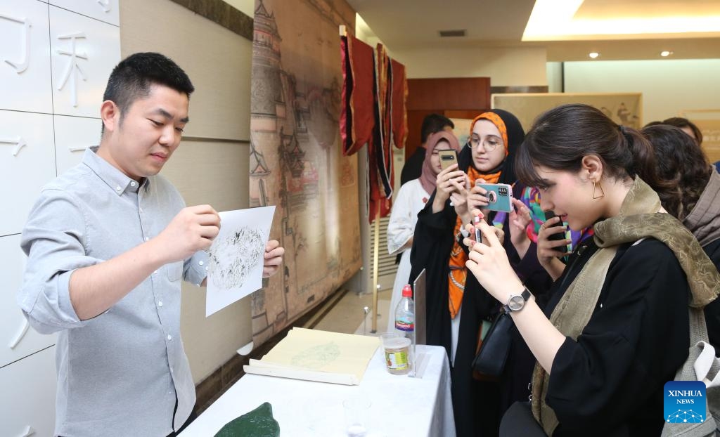 A staff member displays a woodblock printing work at the Chinese Embassy in Tehran, capital of Iran, Sept. 11, 2023.(Photo: Xinhua)