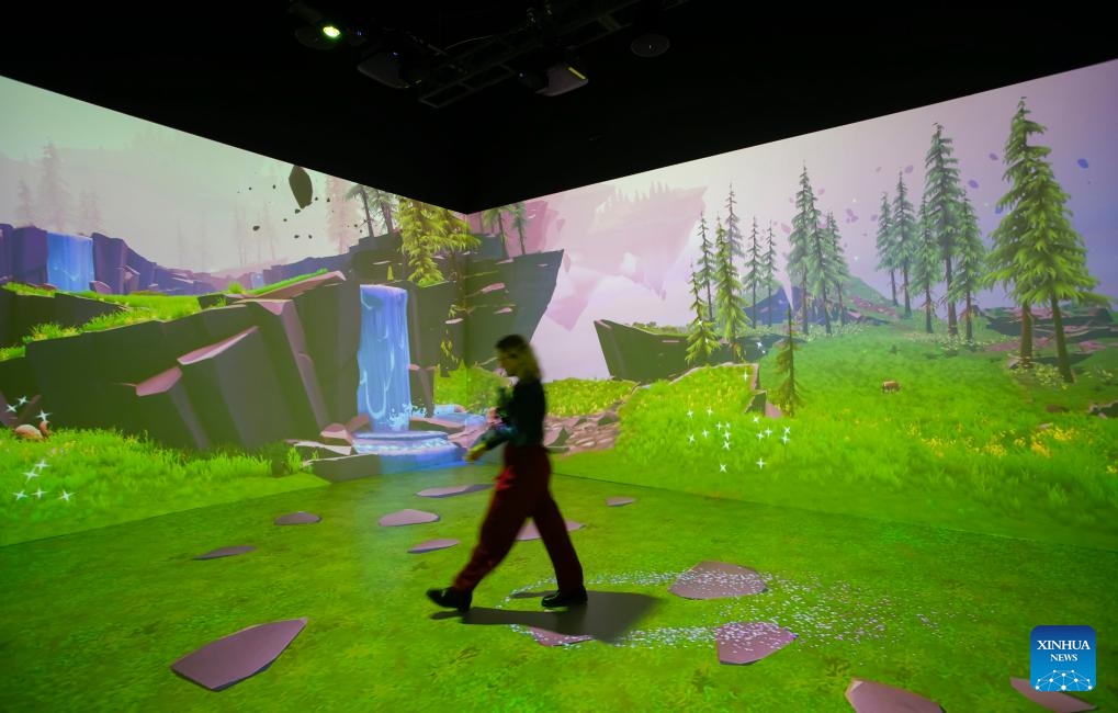 A staff member walks past the interactive digital art projection during the media preview inside the Creative Technology Gallery at the Science World in Vancouver, British Columbia, Canada, on Sept. 13, 2023. The new gallery offering an immersive experience that showcases the fusion of science, technology and art will be opened to the public on Sept. 18(Photo: Xinhua)