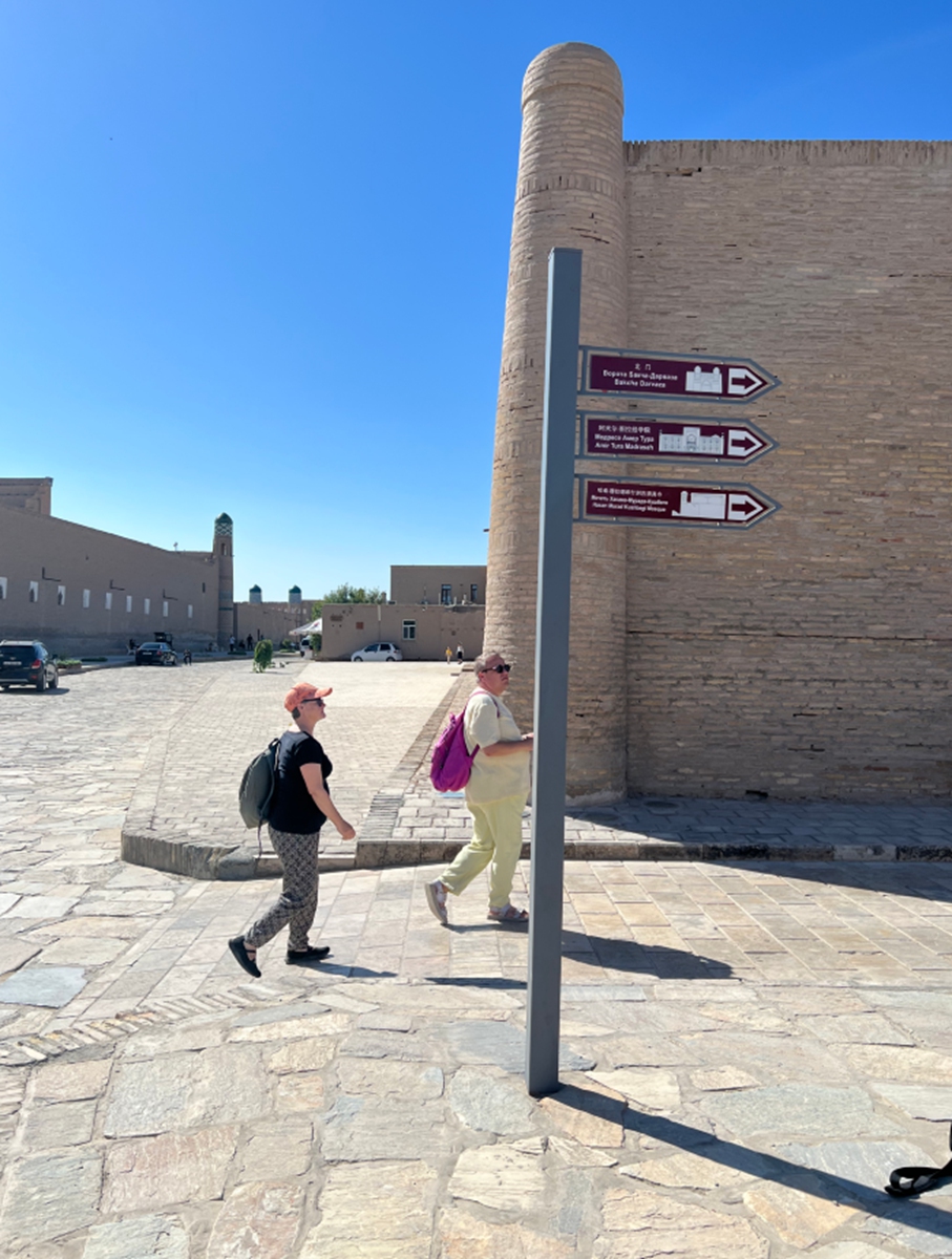 Visitors walk past a road sign that includes Chinese characters in the ancient city of Khiva, Uzbekistan on September 5, 2023. China assisted in the restoration of the Amir Tura Madrasah. Photo: Wang Cong/GT