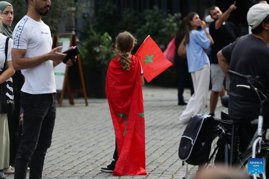 A girl with flags of Morocco attends a memorial service for victims of the earthquake in Morocco, in central Antwerp, Belgium, on Sept. 11, 2023.(Photo: Xinhua)