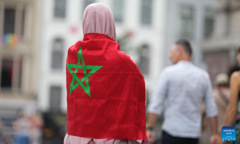 A woman with a flag of Morocco attends a memorial service for victims of the earthquake in Morocco, in central Antwerp, Belgium, on Sept. 11, 2023.(Photo: Xinhua)