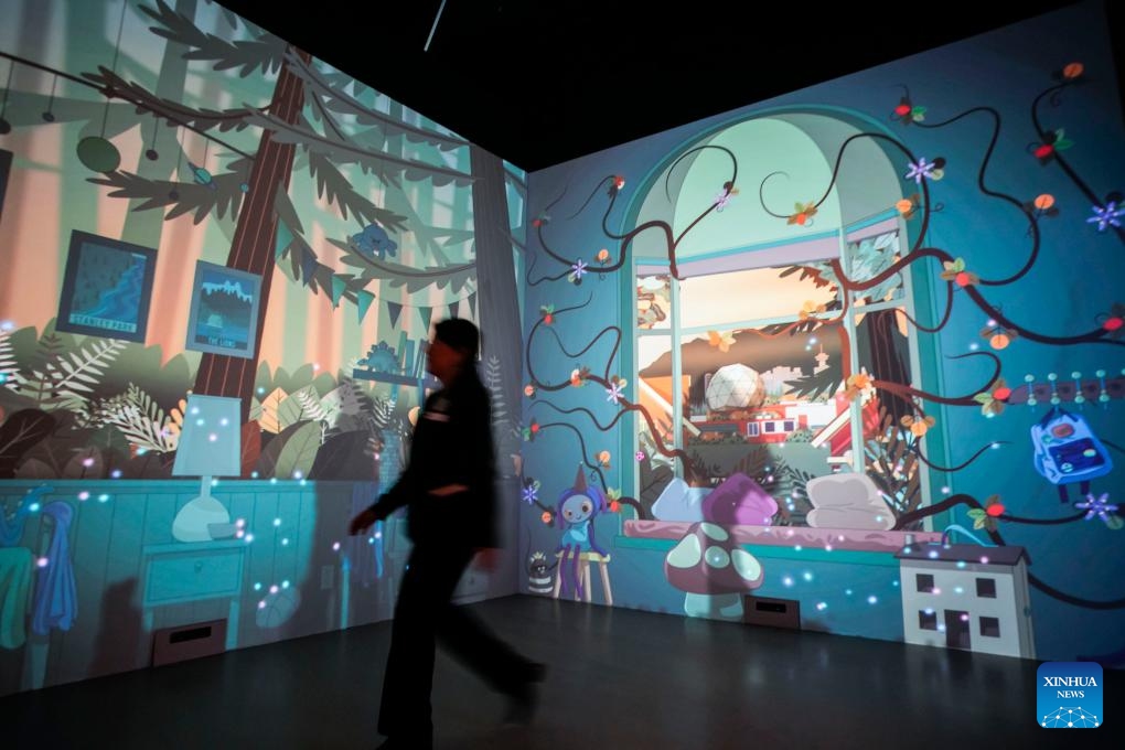 A staff member walks past the interactive digital art projection during the media preview inside the Creative Technology Gallery at the Science World in Vancouver, British Columbia, Canada, on Sept. 13, 2023. The new gallery offering an immersive experience that showcases the fusion of science, technology and art will be opened to the public on Sept. 18.(Photo: Xinhua)