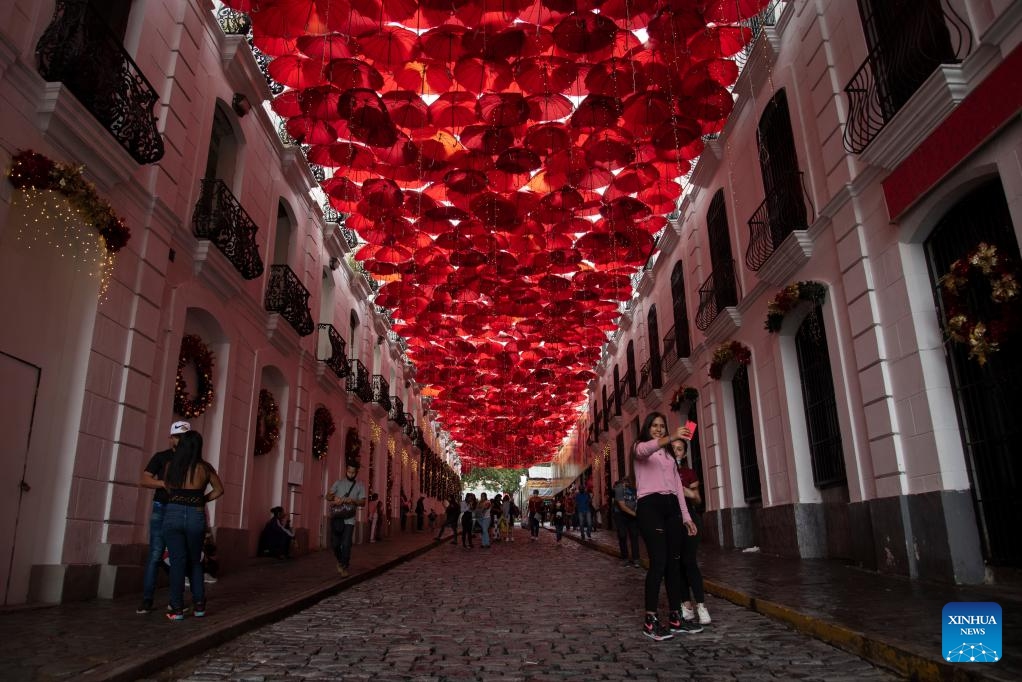People pose for photos on a street in Caracas, Venezuela, Dec. 13, 2021. Venezuela lies along South America's Caribbean coast, bordering Brazil, Colombia and Guyana. The country has rich mineral resources and its oil and gas reserves rank among the top worldwide.(Photo: Xinhua)