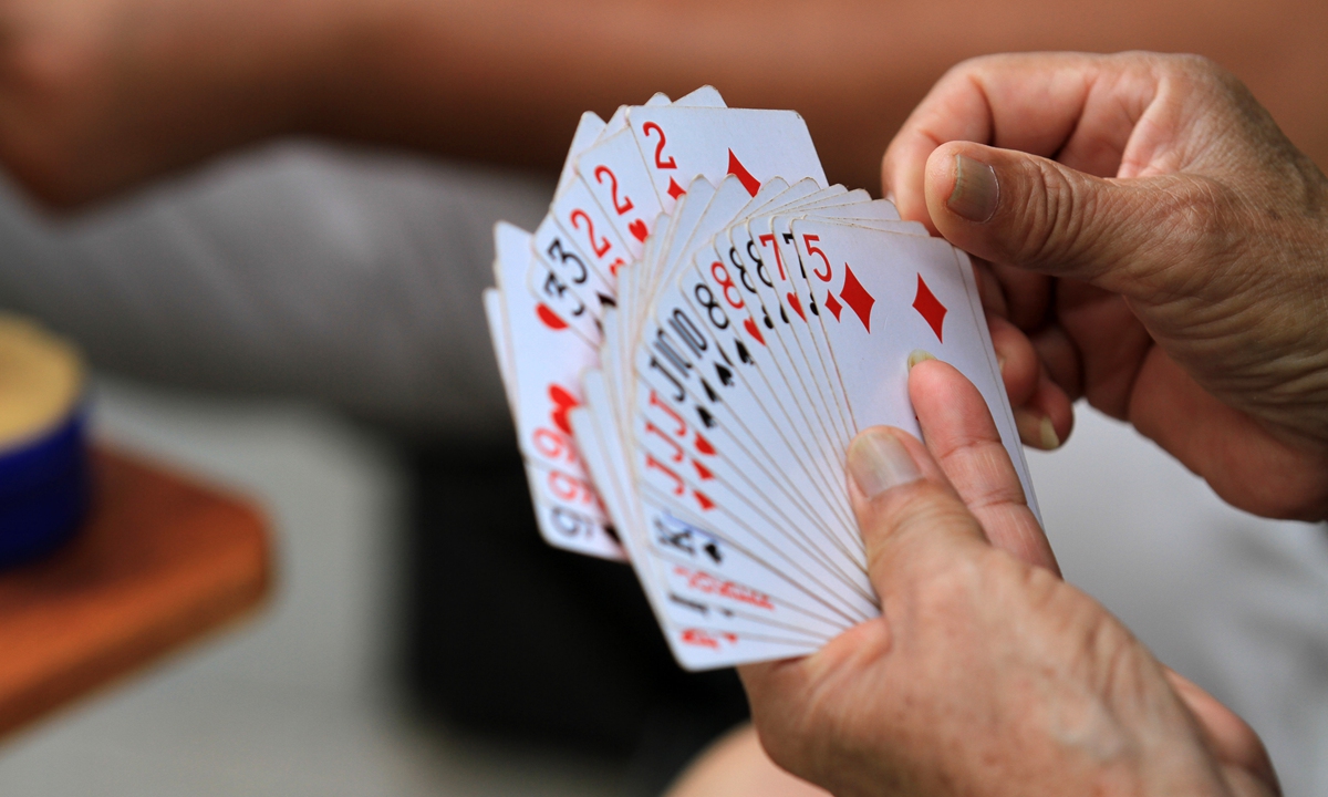 A person plays <em>guandan</em>, a Chinese card game Photo: VCG