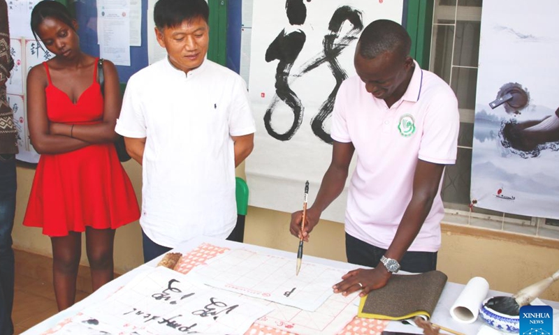 A man tries his hands with Chinese calligraphy at a Chinese cultural exhibition in Kigali, Rwanda, Sept. 23, 2023. Hundreds of Rwandans and Chinese people living in Rwanda braved the afternoon bad weather to attend an action-packed Chinese cultural exhibition in Kigali, the capital of Rwanda, over the weekend. (Photo by Huang Wanqing/Xinhua)