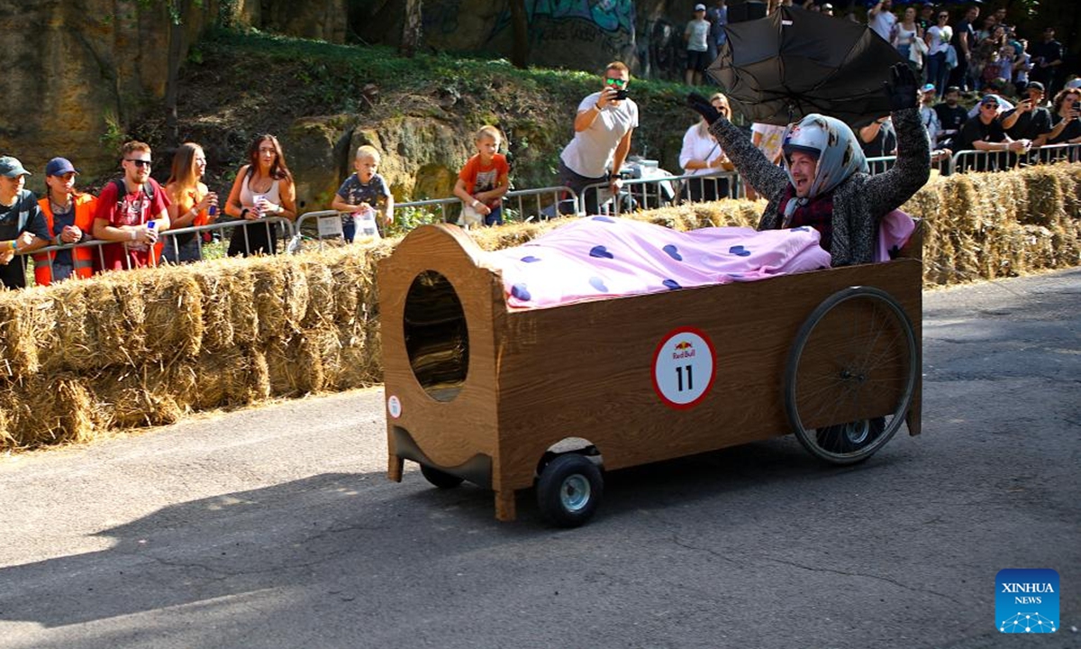 A competitor drives a bed-shaped vehicle during the Red Bull Kary race, a competition of handcrafted, non-motorized vehicles, in Prague, the Czech Republic, on Sept. 16, 2023. A total of 40 selected teams presented their home-made vehicles during the event at Park Kralovka in the Czech capital on Saturday. (Photo by Dana Kesnerova/Xinhua)





