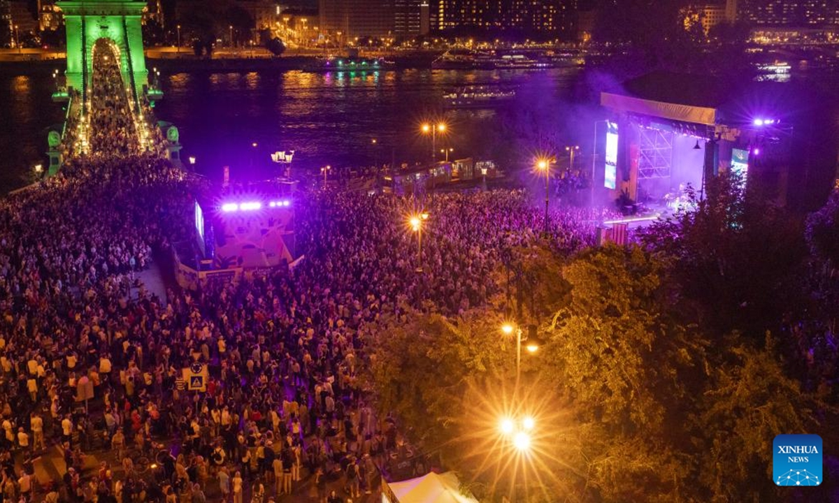 People enjoy the night view by Budapest's landmark Chain Bridge during the Chain Bridge Festival celebrating Budapest's 150th birthday in Budapest, Hungary on Sept. 16, 2023. In 1873, Buda, Pest and Obuda were unified into one single city, naming the city Budapest. (Photo by Attila Volgyi/Xinhua)