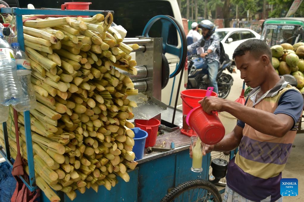 A vendor prepares sugarcane juice at a roadside stall in Dhaka, Bangladesh, Sept. 18, 2023. The early harvest of sugarcane has been in full swing in parts of Bangladesh with the harvesting season extending from September to March next year.(Photo: Xinhua)