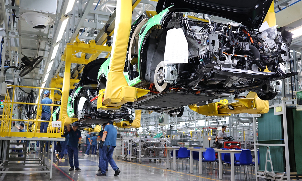 Workers assemble new-energy vehicles (NEVs) at a plant in Southwest China's Chongqing Municipality to fill overseas orders on September 21, 2023. NEV exports totaled 727,000 units in the first eight months of 2023, up 110 percent year-on-year, data from the China Association of Automobile Manufacturers showed. Photo: VCG