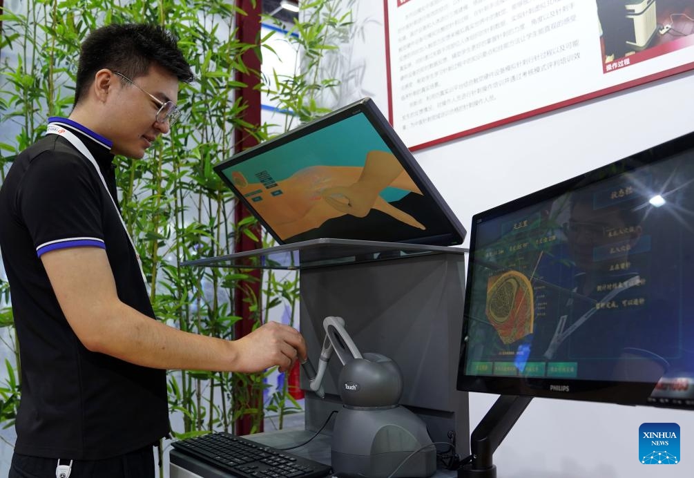 A staff member demonstrates a simulation training system for acupuncture manipulation at the stand of Shanghai University of Traditional Chinese Medicine at the 23rd China International Industry Fair in Shanghai, east China, Sept. 19, 2023. More than 800 projects from over 80 universities are displayed at the exhibition area of universities at the ongoing 23rd China International Industry Fair.(Photo: Xinhua)