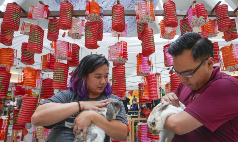 People hold rabbits in front of lanterns during the Meet the Bunnies under the Moon event at the Lansdowne Centre in Richmond, British Columbia, Canada, on Sept. 23, 2023. The two-day family-friendly event kicked off here in Richmond on Saturday, featuring a meet and treat interaction with bunnies rescued by a local animal charity in celebration of the upcoming Mid-Autumn Festival. (Photo by Liang Sen/Xinhua)
