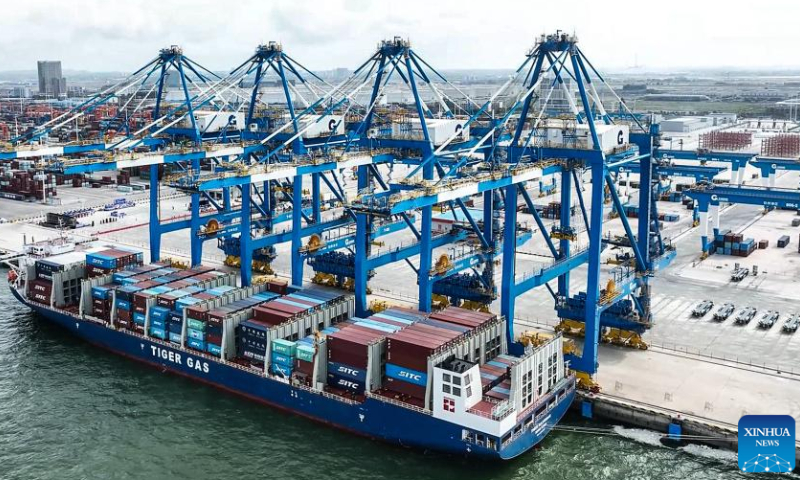 This aerial photo taken on Oct. 2, 2023 shows a container ship docking at an automation wharf of Qinzhou Port for unloading in Qinzhou, south China's Guangxi Zhuang Autonomous Region. Container throughput of the New International Land-Sea Trade Corridor witnessed growth in the first three quarters of 2023, according to railway authorities in south China's Guangxi Zhuang Autonomous Region. During this period, some 633,000 twenty-foot equivalent unit (TEU) containers of goods were transported by rail-sea intermodal trains through the corridor, up 14 percent year on year, data from the China Railway Nanning Group Co., Ltd. showed. Launched in 2017, the New International Land-Sea Trade Corridor is a trade and logistics passage jointly built by provincial-level regions in western China and ASEAN members. The trade corridor has developed rapidly over the years, covering 61 cities in 18 provincial-level regions in China and expanding its reach to 393 ports in 119 countries and regions.（photo：Xinhua）