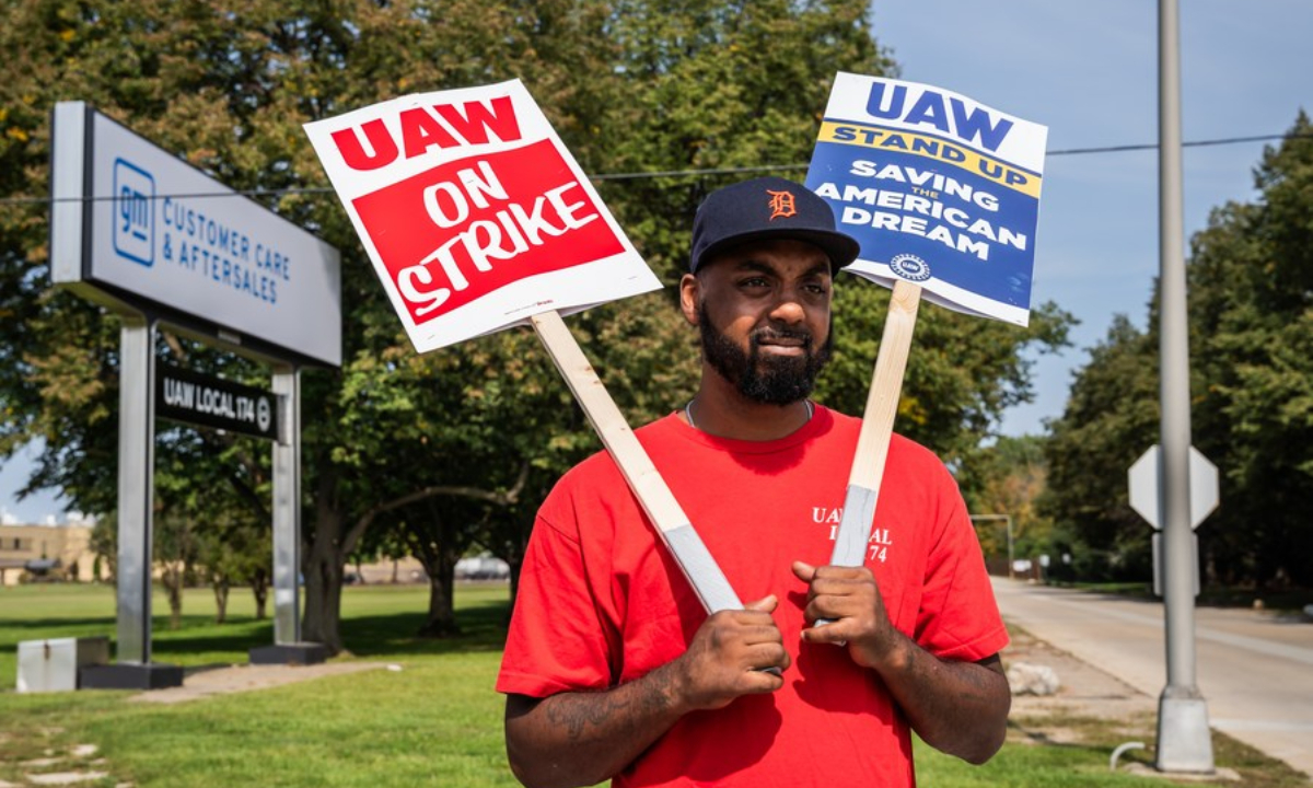 An auto worker holding placards takes part in a strike in Belleville, Michigan, the United States, on Sep 22, 2023.Photo:Xinhua