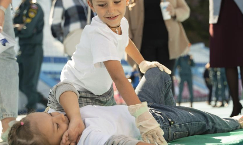 Children learn first-aid skills at a first-aid skills competition in Vladivostok, Russia, Sept. 23, 2023.
The event was aimed at raising public awareness of first aid skills. (Photo by Guo Feizhou/Xinhua)