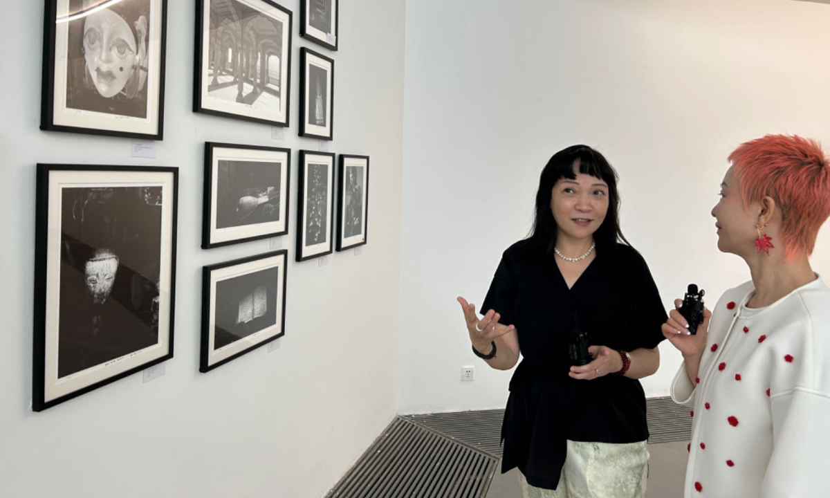 Hong Ying introduces her photography works on display in Beijing on September 28.