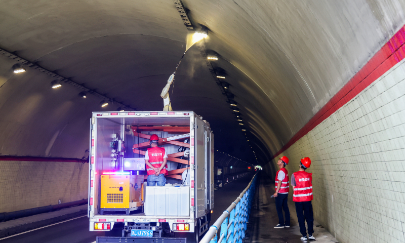 A vehicle-mounted robot washes the lights one by one in the Donggaoling Tunnel in Zhoushan, East China's Zhejiang Province on September 21, 2023. The intelligent tunnel lighting cleaning robot was independently developed by a Zhejiang-based tech firm for all kinds of highway tunnels, which can increase the brightness of lighting by more than 20 percent. Photo: VCG