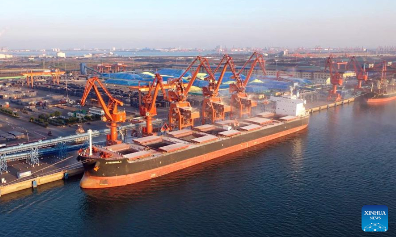 This aerial photo taken on Sept. 16, 2023 shows a vessel docking at the bulk cargo terminal for unloading in Fangchenggang, south China's Guangxi Zhuang Autonomous Region. Container throughput of the New International Land-Sea Trade Corridor witnessed growth in the first three quarters of 2023, according to railway authorities in south China's Guangxi Zhuang Autonomous Region. During this period, some 633,000 twenty-foot equivalent unit (TEU) containers of goods were transported by rail-sea intermodal trains through the corridor, up 14 percent year on year, data from the China Railway Nanning Group Co., Ltd. showed. Launched in 2017, the New International Land-Sea Trade Corridor is a trade and logistics passage jointly built by provincial-level regions in western China and ASEAN members. The trade corridor has developed rapidly over the years, covering 61 cities in 18 provincial-level regions in China and expanding its reach to 393 ports in 119 countries and regions. （photo：Xinhua）