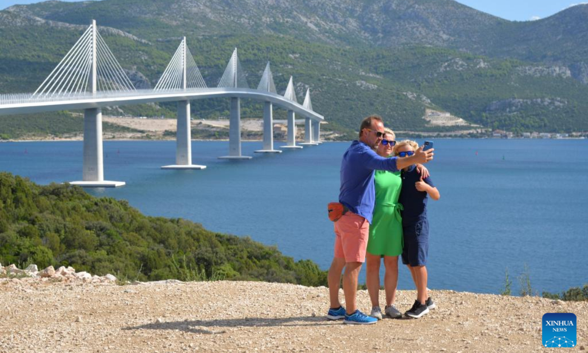 People take souvenir photos in front of the Peljesac Bridge in Komarna, Croatia, on Aug 29, 2023. The bridge, a project of China's Belt and Road Initiative (BRI), was opened for traffic on July 26 last year. Photo:Xinhua