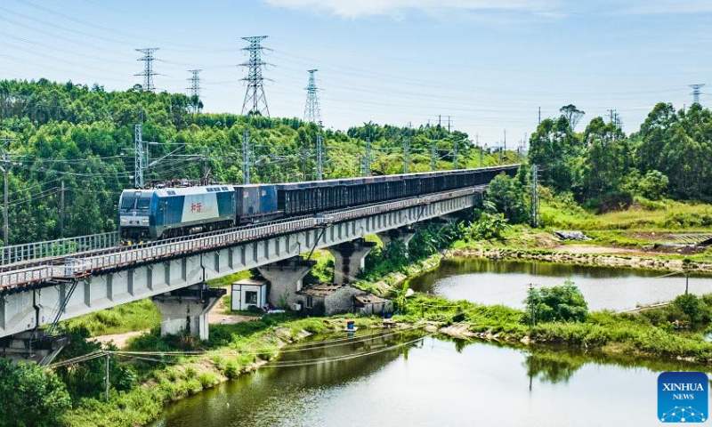 This aerial photo taken on Oct. 2, 2023 shows a train loaded with goods departing from Qinzhou Port East Railway Station in Qinzhou, south China's Guangxi Zhuang Autonomous Region. Container throughput of the New International Land-Sea Trade Corridor witnessed growth in the first three quarters of 2023, according to railway authorities in south China's Guangxi Zhuang Autonomous Region. During this period, some 633,000 twenty-foot equivalent unit (TEU) containers of goods were transported by rail-sea intermodal trains through the corridor, up 14 percent year on year, data from the China Railway Nanning Group Co., Ltd. showed. Launched in 2017, the New International Land-Sea Trade Corridor is a trade and logistics passage jointly built by provincial-level regions in western China and ASEAN members. The trade corridor has developed rapidly over the years, covering 61 cities in 18 provincial-level regions in China and expanding its reach to 393 ports in 119 countries and regions.（photo：Xinhua）