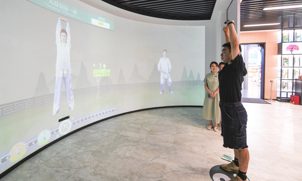 Visual Chinese traditional exercise classes are provided through a big screen inside the Main Media Center of the Asian Games. Photos: VCG