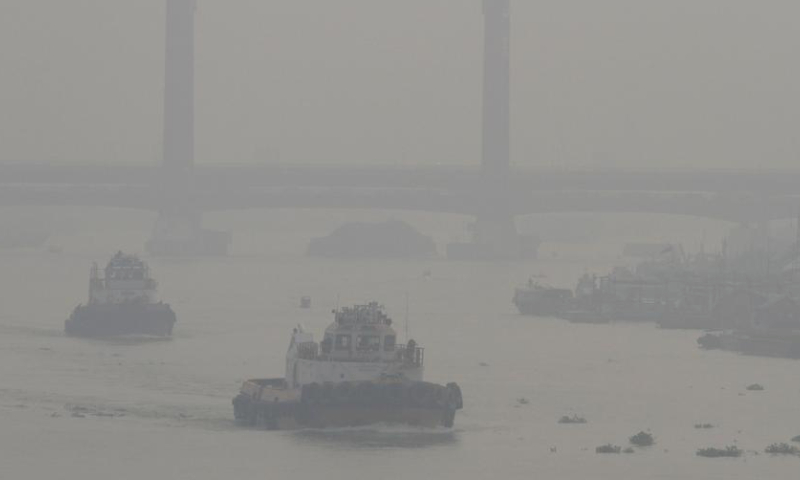 Ships sail on a river in peatland fire-induced smoke in Palembang, South Sumatra, Indonesia, Oct. 3, 2023. (Photo by M. Hatta/Xinhua)