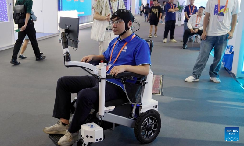 A staff member from the stand of Shanghai University demonstrates a brain-controlled rehabilitation wheelchair at the 23rd China International Industry Fair in Shanghai, east China, Sept. 20, 2023. More than 800 projects from over 80 universities are displayed at the exhibition area of universities at the ongoing 23rd China International Industry Fair.(Photo: Xinhua)