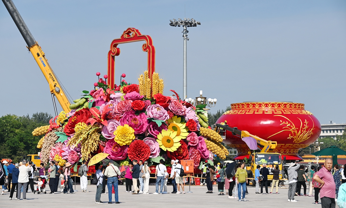 Tourists take photos in front of a giant flower basket being placed at Tian'anmen Square in downtown Beijing on September 21, 2023 to celebrate the upcoming National Day holidays, which will begin on October 1. Photo: VCG