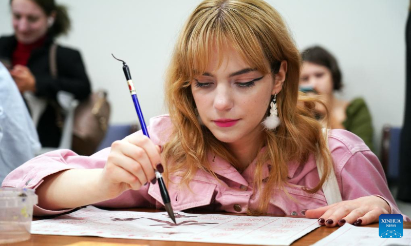 A person practices Chinese calligraphy during an event celebrating the Mid-Autumn Festival held by the Confucius Institute at the University of Latvia in Riga, Latvia, Sept. 25, 2023. Various celebrations are held across the world with the approaching of Mid-Autumn Festival. (Photo by Janis/Xinhua)