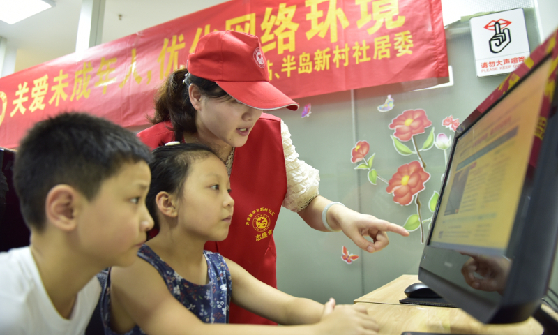 A community volunteer explains internet safety knowledge to children in Hefei, Anhui Province on July 29, 2020. Photo: VCG