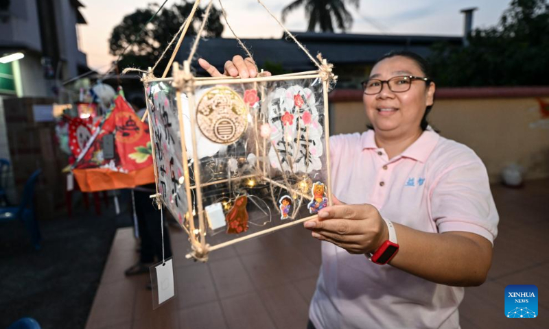 A woman shows a lantern during a mid-autumn festival gala in Malacca, Malaysia, Sept. 27, 2023. (Xinhua/Cheng Yiheng)