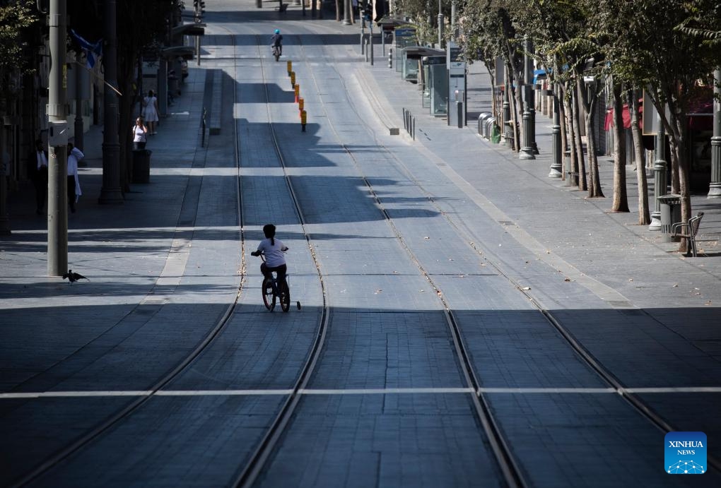 A child rides a bicycle on a road during Yom Kippur in Jerusalem, on Sept. 25, 2023. Yom Kippur, Jewish Day of Atonement, is a solemn day of reflection and fasting, on which most automobiles are not allowed on roads.(Photo: Xinhua)