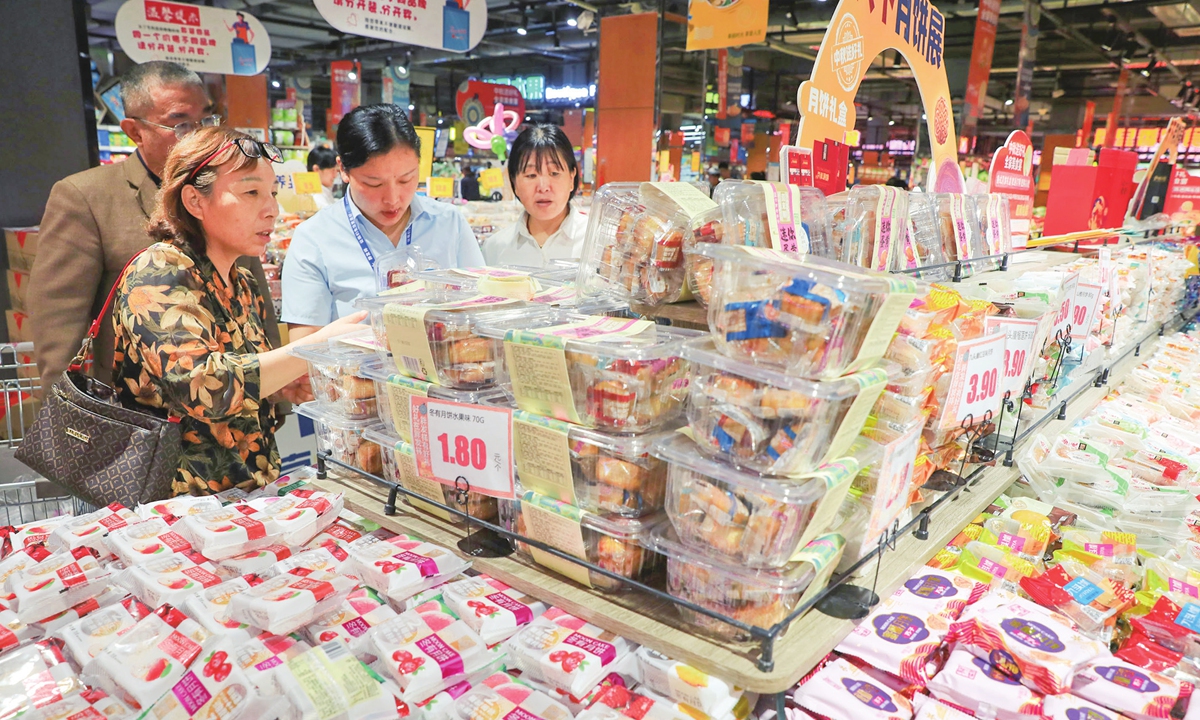 Customers browse mooncakes at a supermarket in Jiaozuo, Central China's Henan Province on September 24, 2023. As the Mid-Autumn Festival approaches, mooncake sales have peaked in supermarkets and pastry stores across the country, and mooncakes with simple packaging are more popular among consumers. Photo: VCG