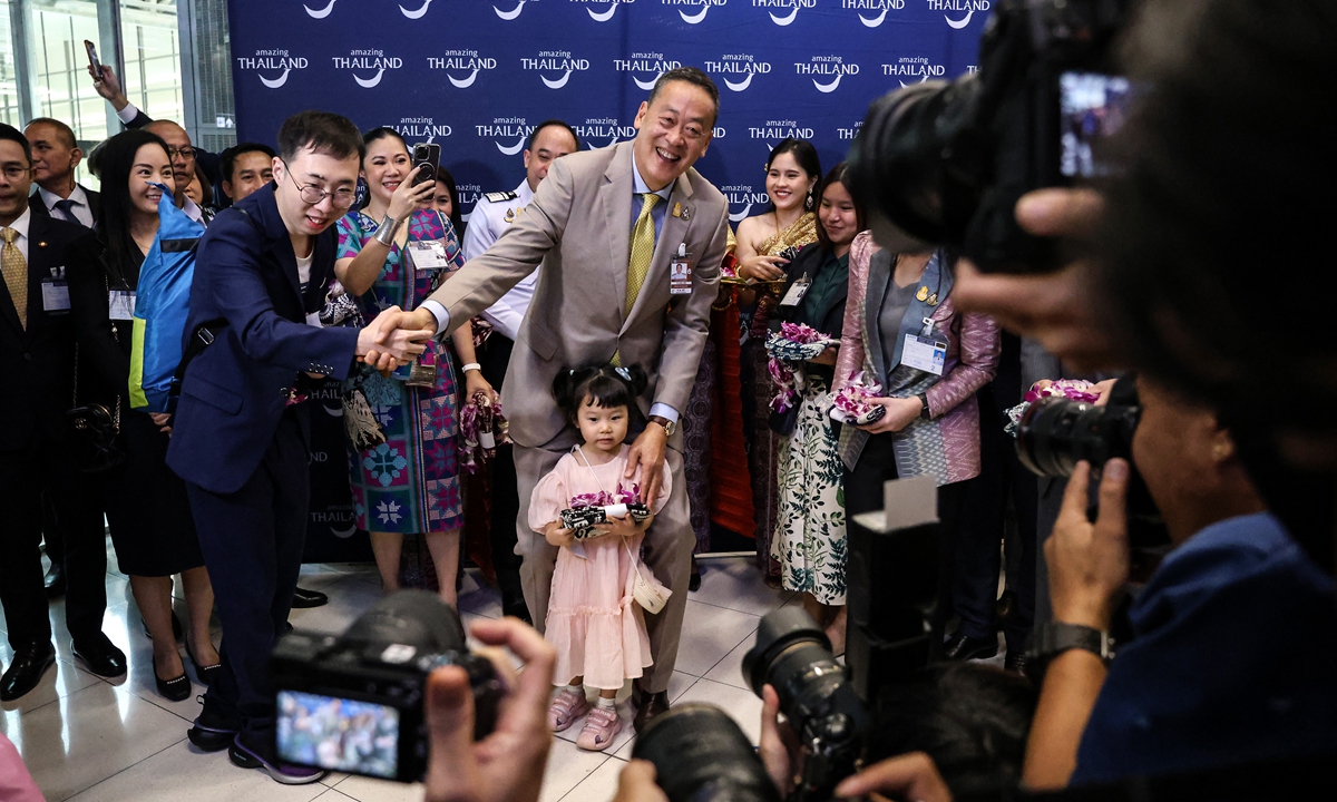 Srettha Thavisin (center), Thailand's prime minister, poses for photographs with visitors during an event to welcome inbound tourists from China at Suvarnabhumi Airport in Bangkok, Thailand, on September 25, 2023.Photo:VCG
