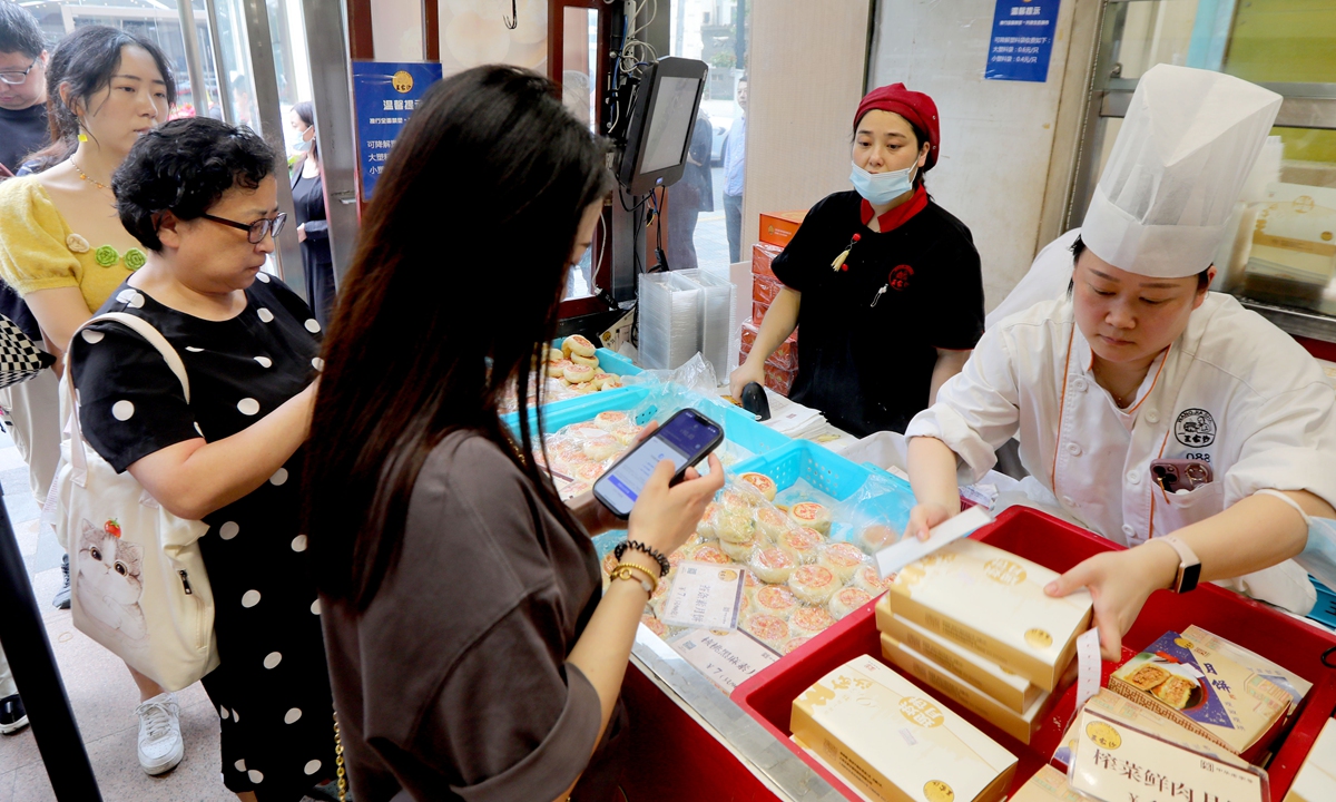 Residents queue for mooncakes at a store in Shanghai on September 27, 2023, days ahead of the Mid-Autumn Festival, which falls on September 29. In addition to traditional fillings such as fresh meat, mixed nuts, and crab meat, a new variety of mooncake with a filling of fresh coconut and latte has been introduced this year. Photo: Chen Xia/GT