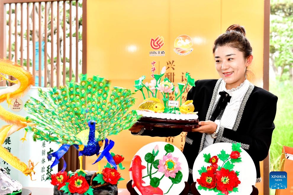 A staff member displays a dough modelling art work during the Ninth Nishan Forum on World Civilizations in Qufu, east China's Shandong Province, Sept. 26, 2023. Held from Tuesday to Thursday in the city of Qufu, the birthplace of ancient Chinese sage Confucius (551 B.C.-479 B.C.), the forum offers a platform for renowned scholars and experts in cultural studies to forge better understanding on enhancing dialogues among different cultures.(Photo: Xinhua)