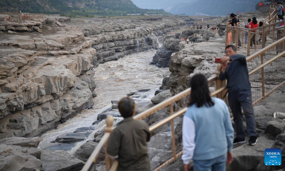 Tourists enjoy the autumn scenery of the Hukou Waterfall on the Yellow River, on the border area between north China's Shanxi and northwest China's Shaanxi provinces, on Sept. 26, 2023. (Xinhua/Shao Rui)







