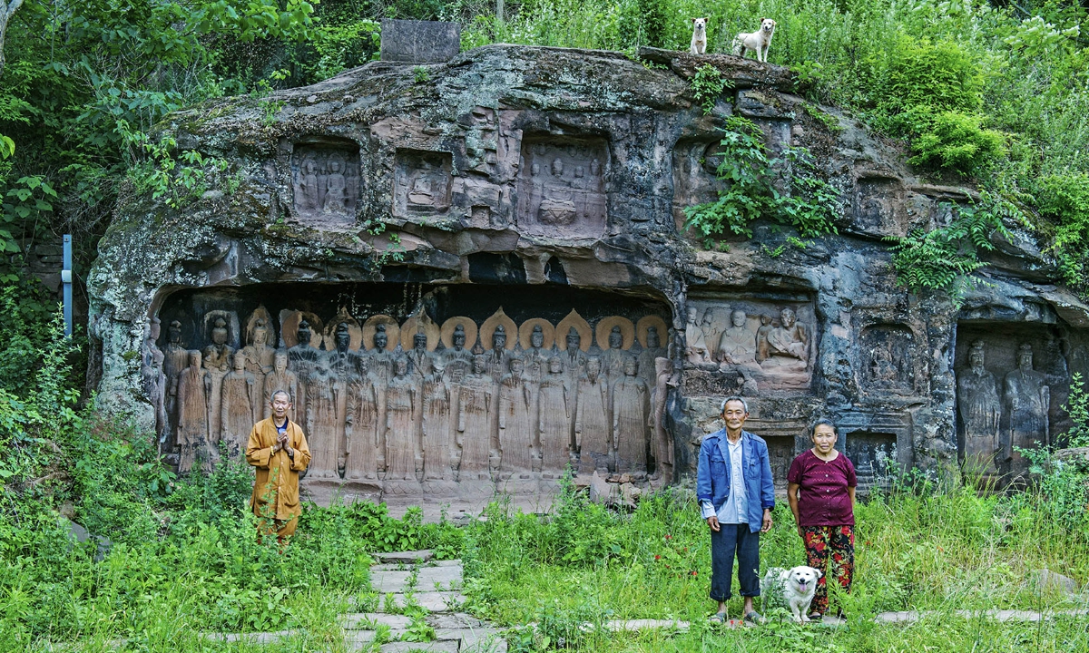 Huang Tianming, his wife, Shi Yuexin, and the family dog pose for photo in May, 2018. Two other dogs raised by Huang Tianming to guard the relics appearing above the rock face (top right). Photo: Courtesy of Yuan Rongsun