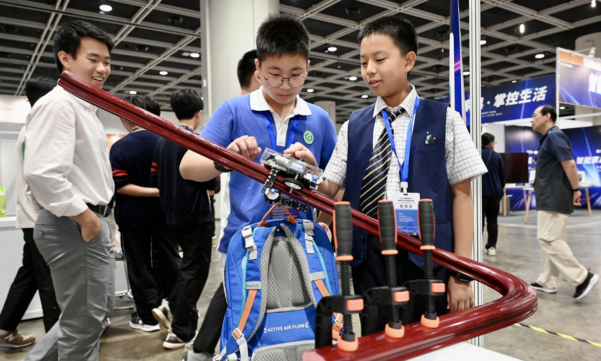 Two teenage visitors try out some new technology at an innovation exhibition held in Hong Kong on October 6, 2023. The expo mainly covers artificial intelligence, robotics applications, fintech, digital currencies and e-payment services, in order to promote the development of Hong Kong's new technological ecosystem. Photo: VCG