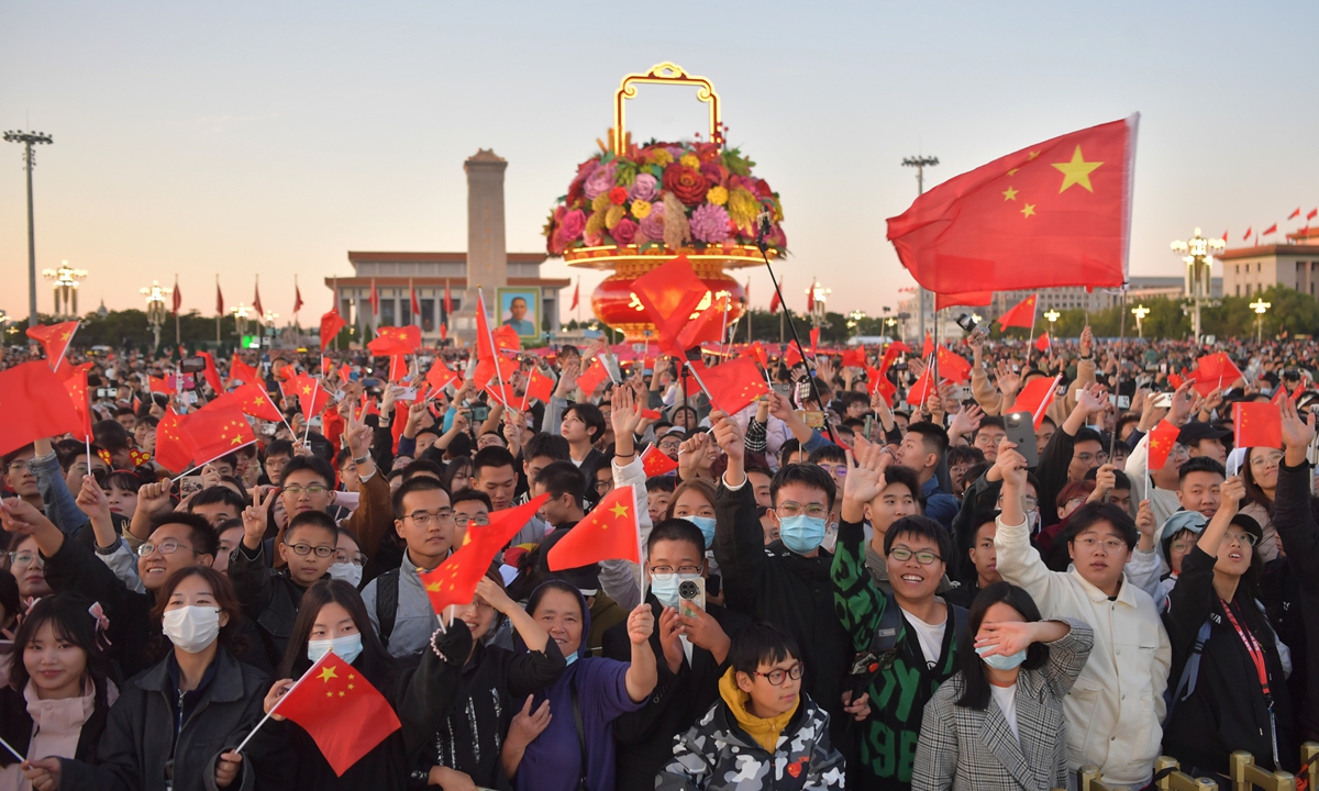 People wave national flags as they watch the National Day flag-raising ceremony at Tiananmen Square in Beijing on October 1, 2023, on the 74th anniversary of the founding of the People's Republic of China. Photo: VCG