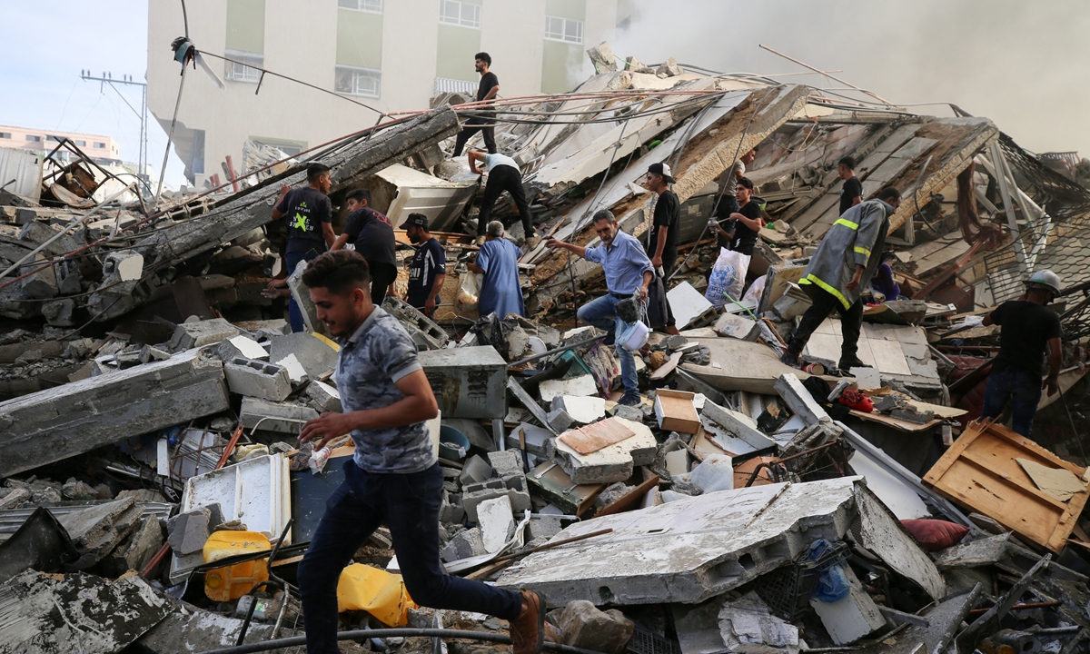 People assess the destruction cause by Israeli air strikes in Gaza City on October 7, 2023. Photo: AFP