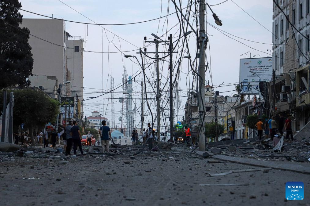 Palestinians check destroyed buildings following an Israeli airstrike in Gaza City, Oct. 8, 2023. Israel's cabinet declared a state of war on Sunday after a massive surprise attack launched by Hamas has so far killed at least 700 in Israel while retaliatory Israeli airstrikes killed at least 413 in Gaza.(Photo: Xinhua)